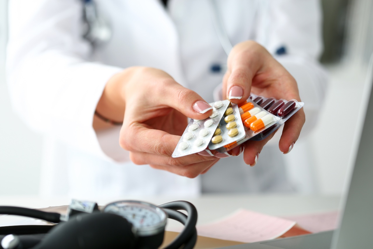 Ärztin hält in der Hand eine Packung verschiedener Tablettenblister am Arbeitsplatz in Nahaufnahme